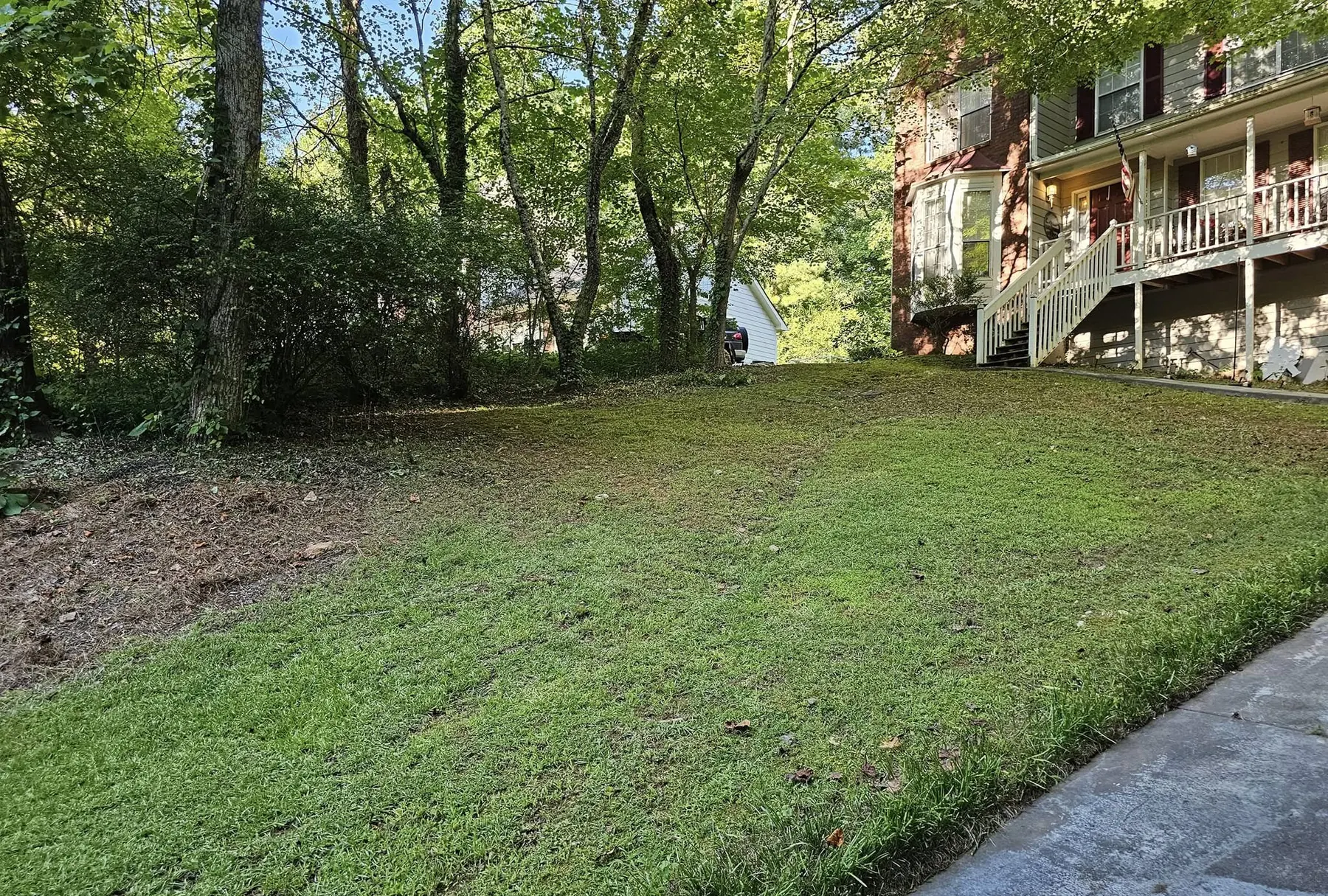 Sloped lawn cleared and cut behind a home