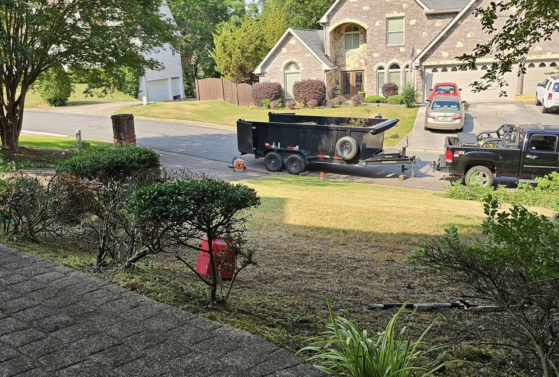 KND Tree Service truck and dump trailer on a job in a Woodstock neighborhood