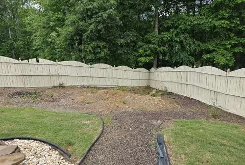 Curved bed edging and mulch along a fence